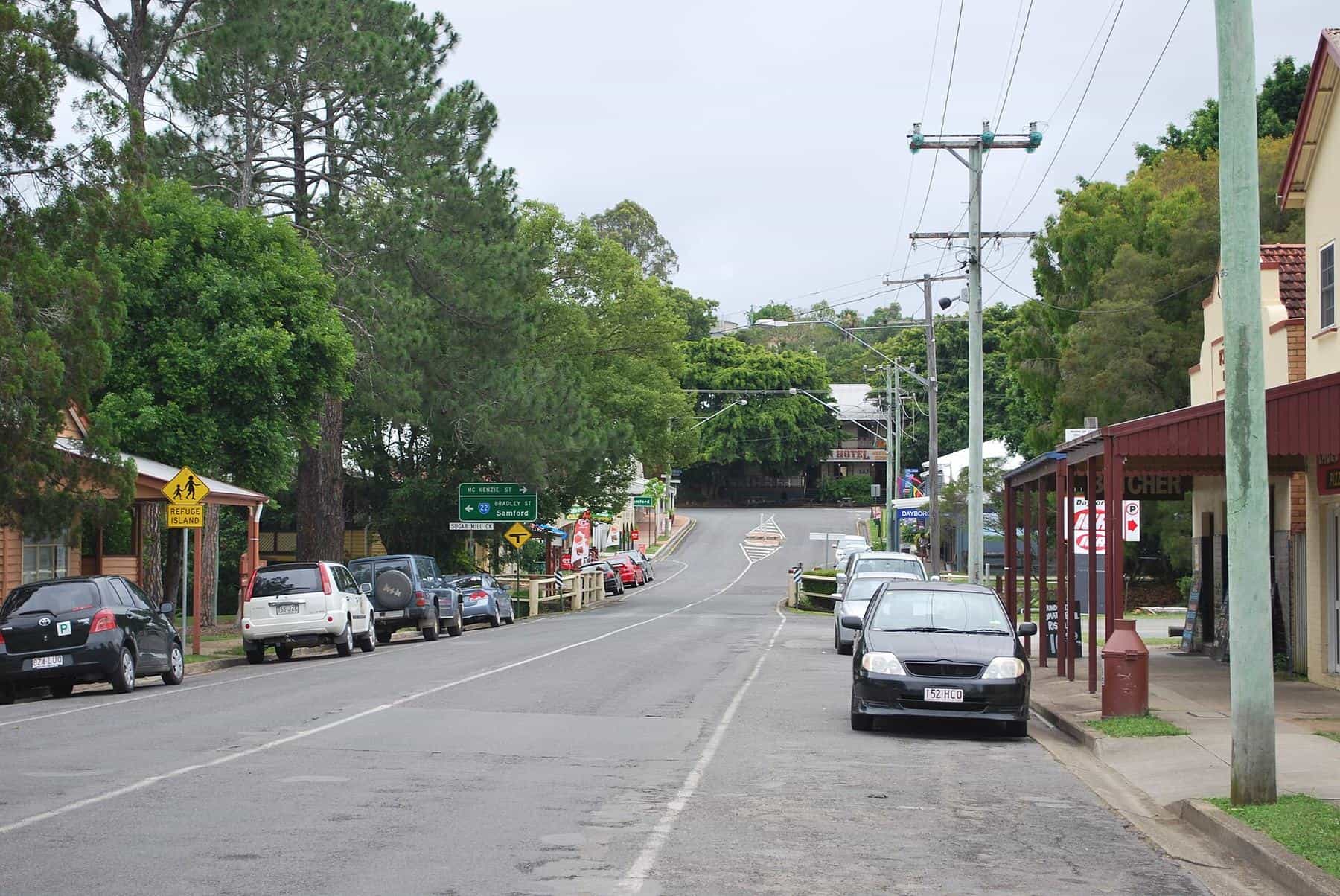 The wide main street of Dayboro with low shopfronts and verandahs under a blue sky