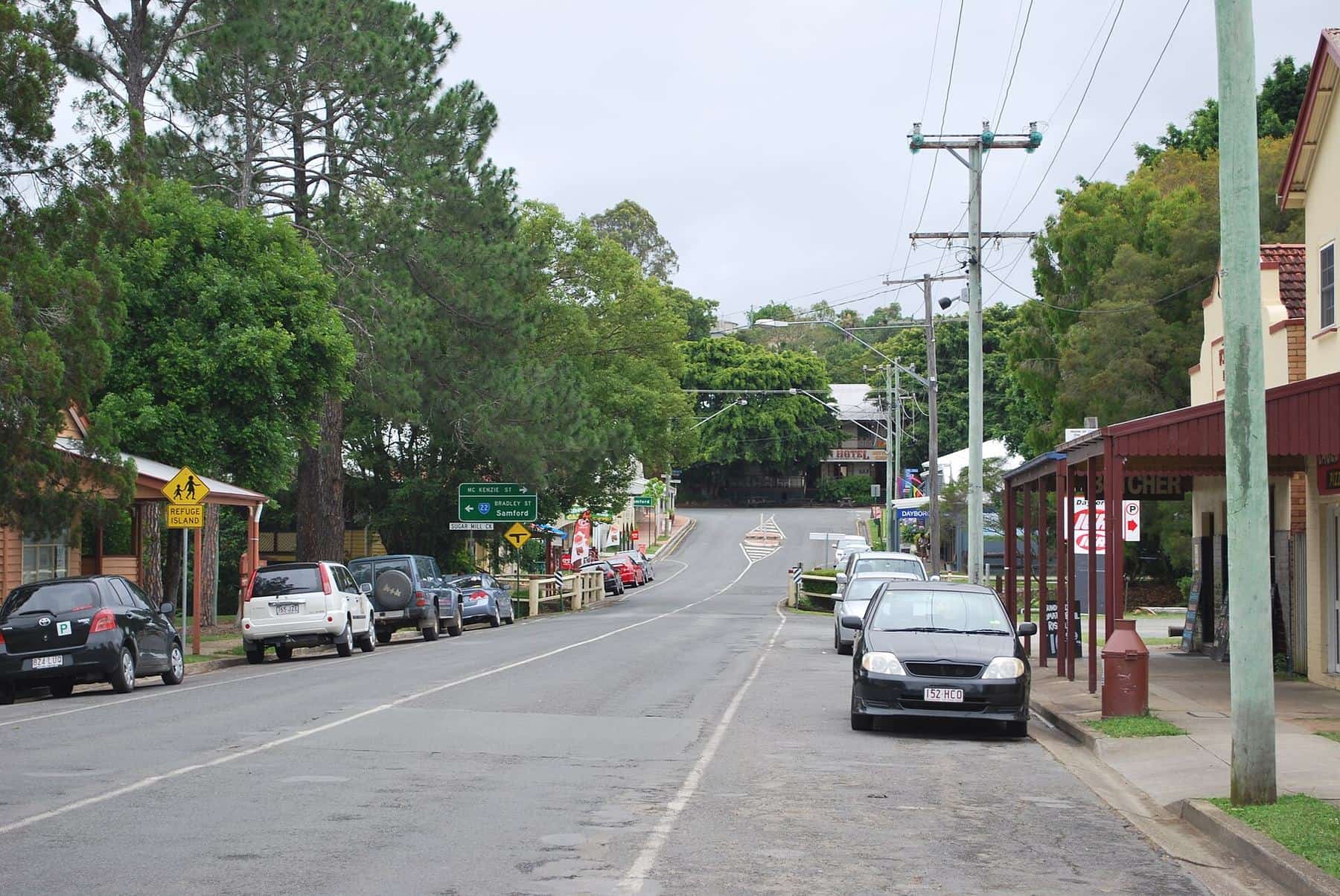 The wide main street of Dayboro with low shopfronts and verandahs under a blue sky