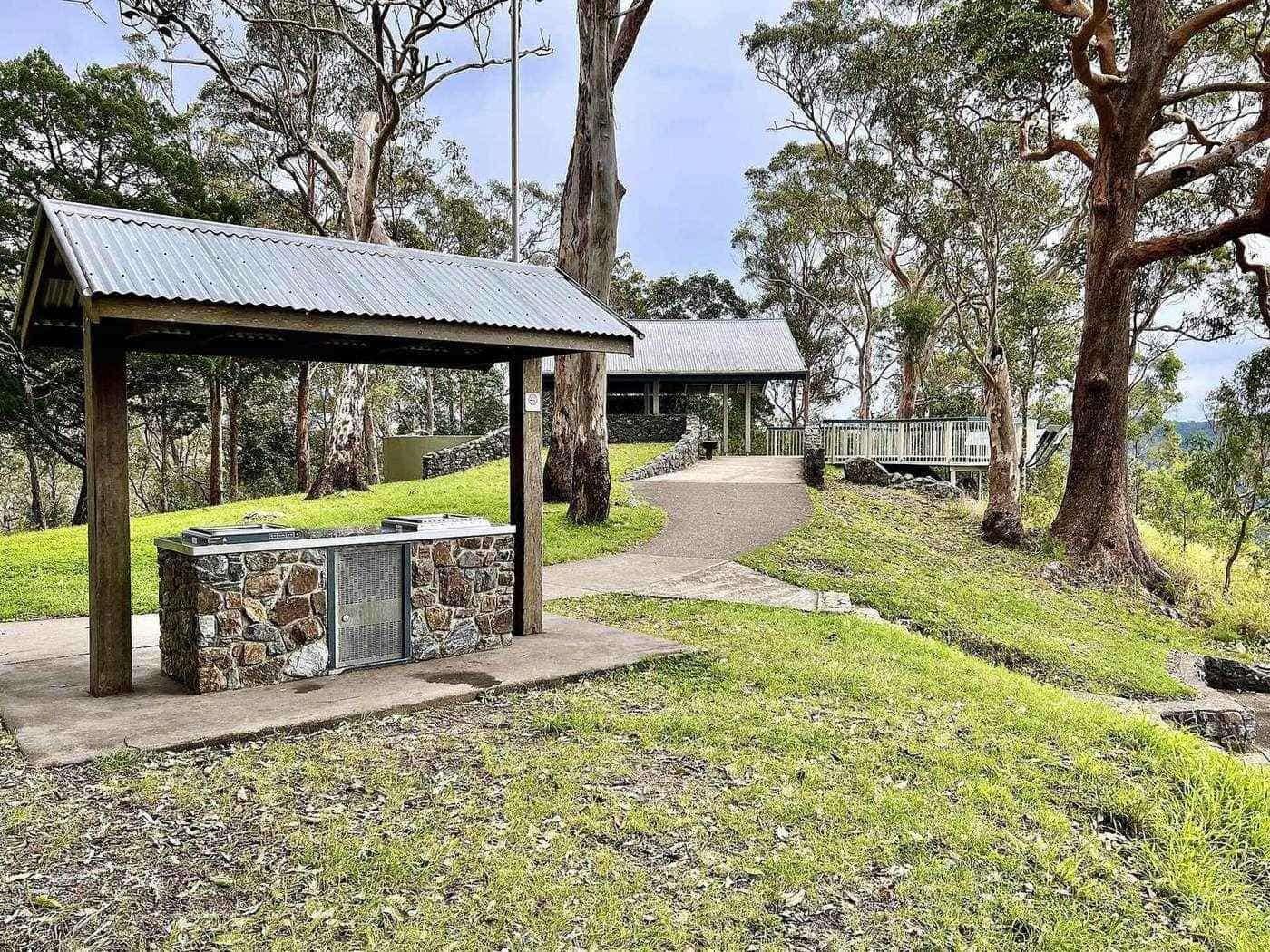A picnic shelter at a grassy lookout on the forest edge with a wide hazy view east